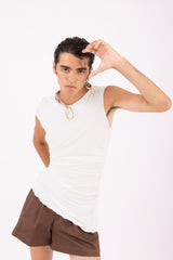 Top asimmetrico avorio dettaglio taglio asimmetrico design contemporaneo